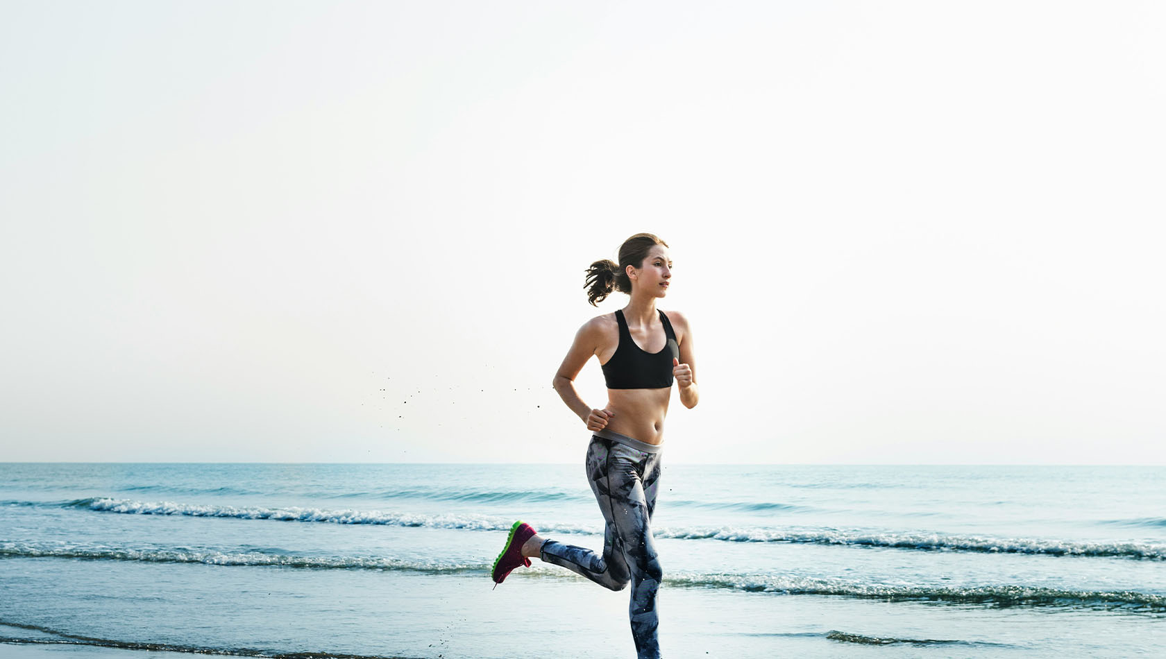 Liquid Glass display with clear app icons, like Apple Music, Reminders, Photos, Games, Podcasts, and FaceTime refracting against the wallpaper